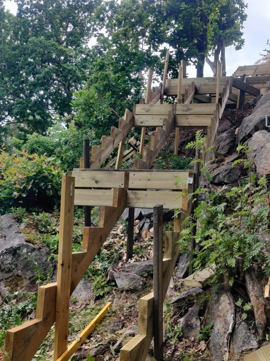 Flera trappsektioner möter bergsluttningen på arbetsplatsen i Tyresö.